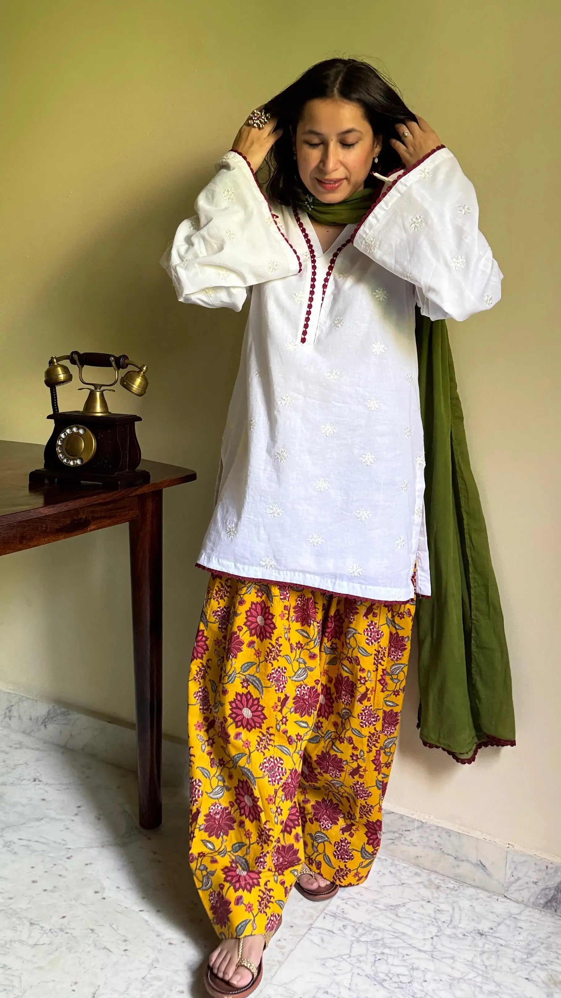 Pyoor’s Marigold Farshi Salwar Suit Set with white kurta, yellow salwar, and green lace dupatta.